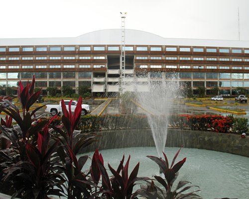 Scenic exterior view of Gran Hotel Ccp Suites with the waterfront and fountain.
