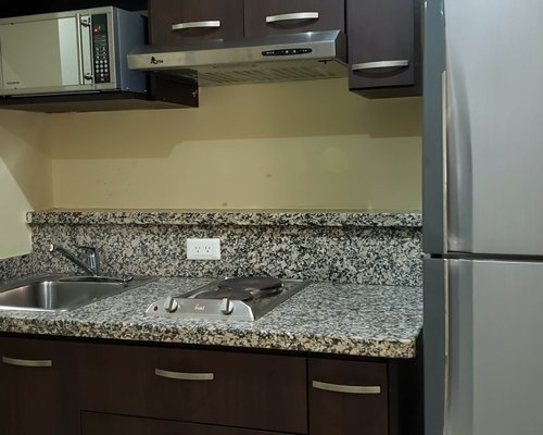 A kitchen with a microwave oven and refrigerator.