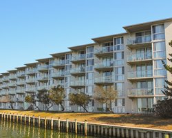 An exterior view of the multi story resort unit alongside the waterfront.