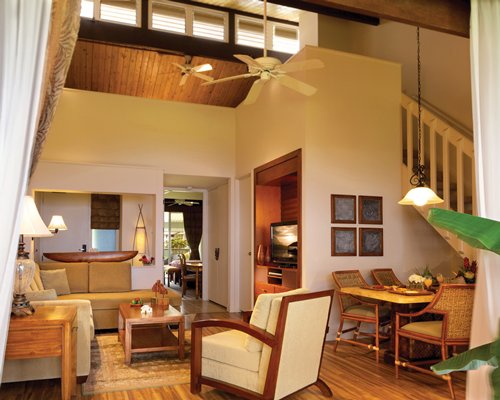 A view of open living and dining area with high wooden ceiling.