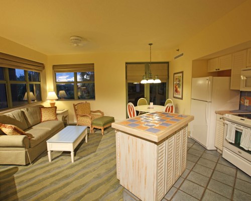 A WELL FURNISHED LIVING ROOM WITH AN OPEN PLAN KITCHEN AND DINING AREA.