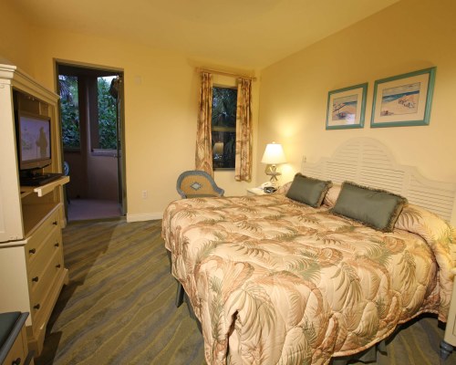 A WELL FURNISHED BEDROOM WITH A TELEVISION.