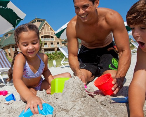 A FAMILY PLAYING WITH SAND.