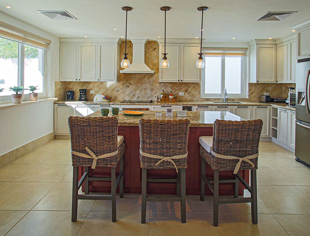 View of kitchen island with three chairs set for breakfast