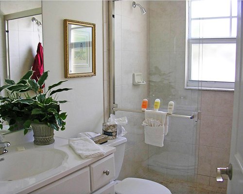 A bathroom with a stand up shower and single sink vanity.