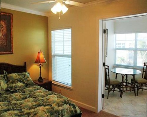 A well furnished bedroom with a lamp alongside the dining area with an outside view.