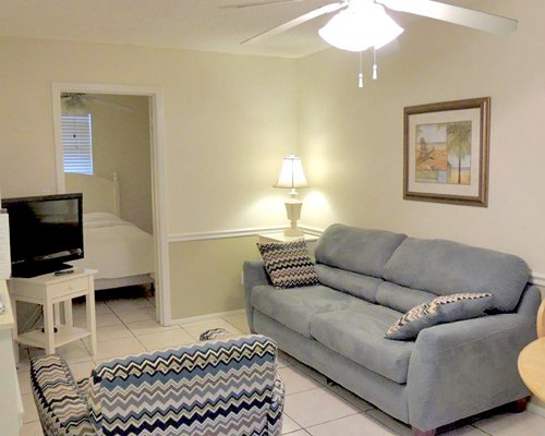 A well furnished living room with a television alongside bedroom.
