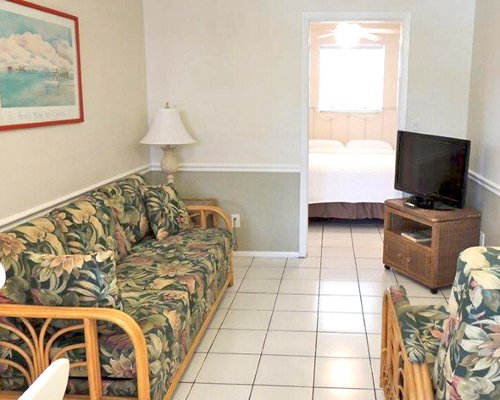 A well furnished living room with a television alongside a bedroom.