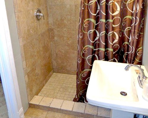 A bathroom with a shower stall and single sink.