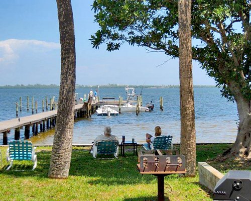 Scenic picnic area with barbecue grill chaise lounge chairs and the waterfront.