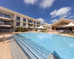 An outdoor swimming pool with chaise lounge chairs.