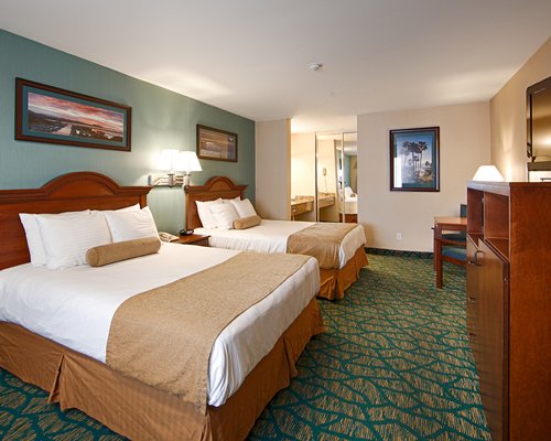A bedroom with two large beds and bathroom.