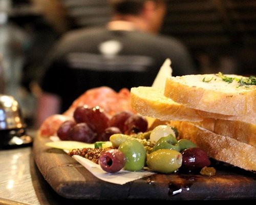 Close up of assorted foods and bread on cutting board.