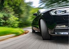 An image of a fast, black car driving on the road