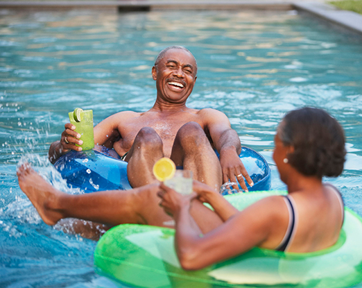 A couple riding floating rings in the pool