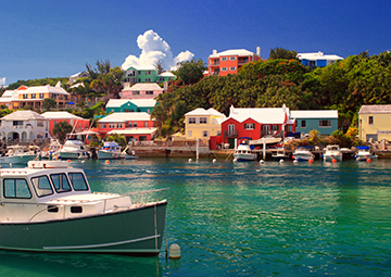 Image of the seaside homes and a boat on the water in the Caribbean