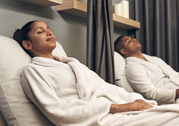 A couple relaxing in robes at a spa