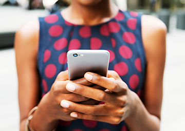 A Black woman using apps on her phone