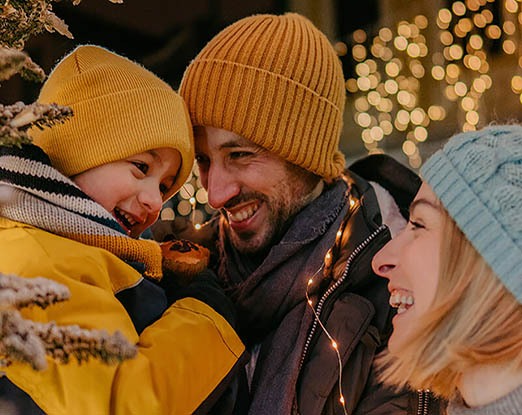 A family in winter wear hugging and smiling