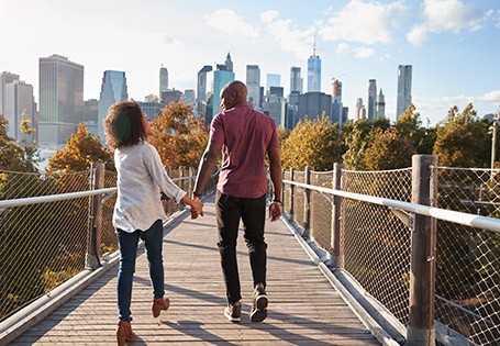 Couple walking on a bridge through the city