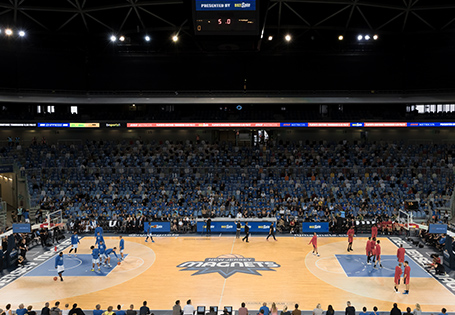 A basketball court with players warming up before the game