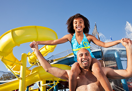 Daughter on her father's shoulders at a water park