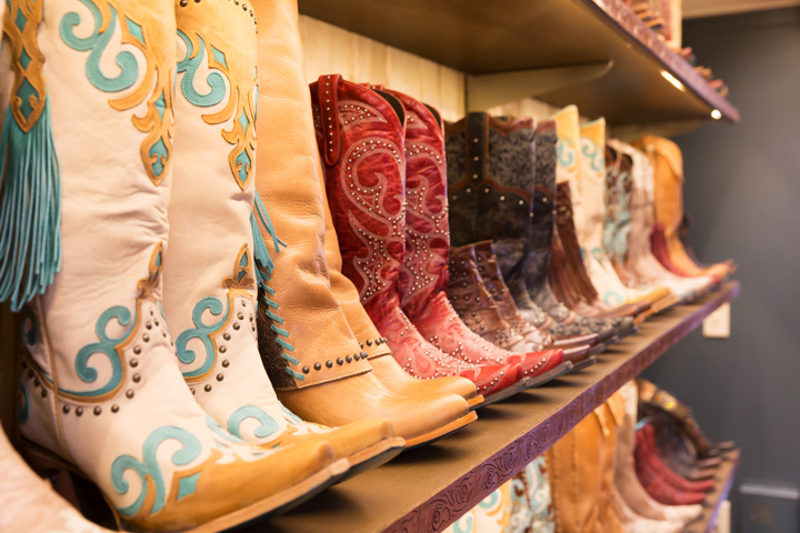 A shelf full of cowboy boots
