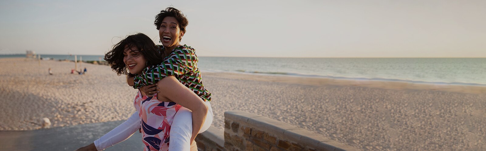 An older woman piggyback riding a younger woman's back