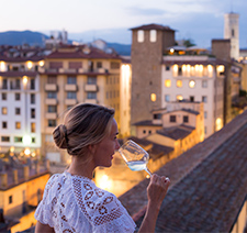 A woman drinking wine on a rooftop