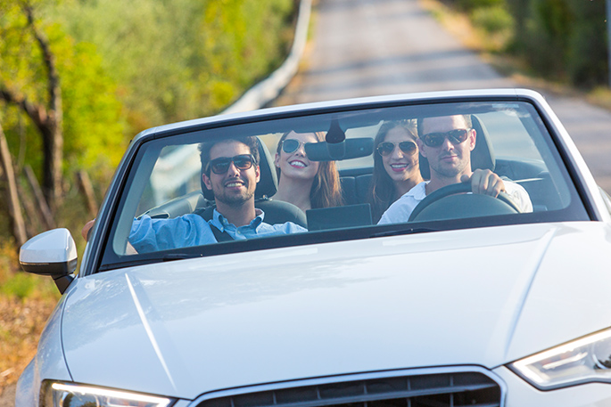 Four friends riding in a convertible