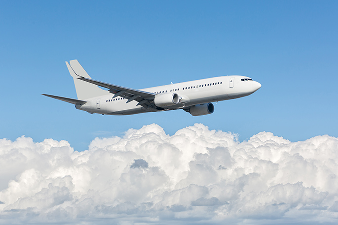 A plane flying through the cloudy sky