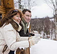 Man and Woman on winter holiday at cabin enjoying the snow